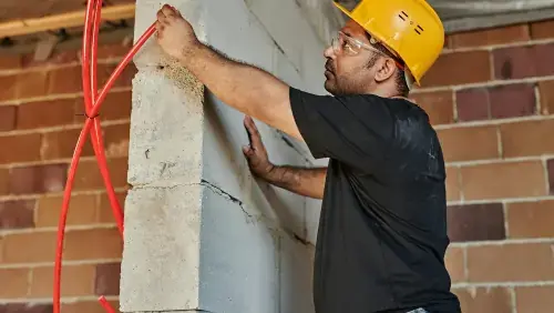 NJ home improvement expert performing exterior siding and masonry work on a brick wall construction site