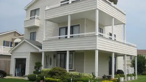 Multi-level residential exterior before deck and siding renovation in New Jersey